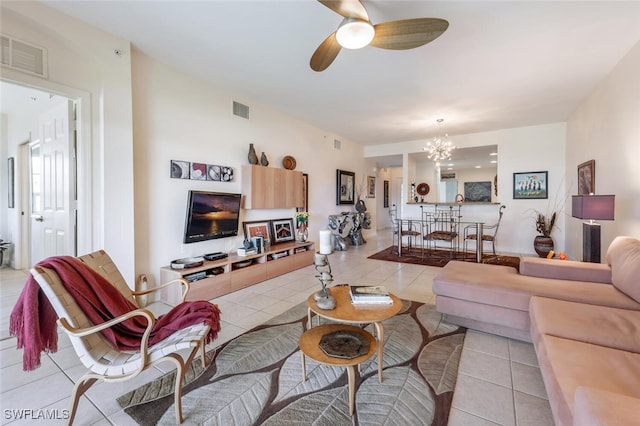 living room featuring ceiling fan with notable chandelier and light tile patterned flooring