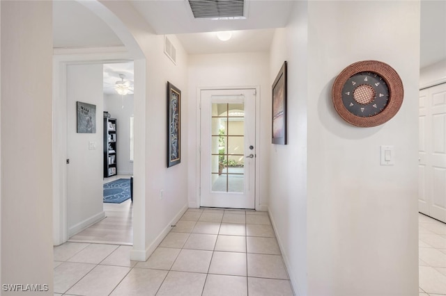 doorway featuring light tile patterned floors and ceiling fan