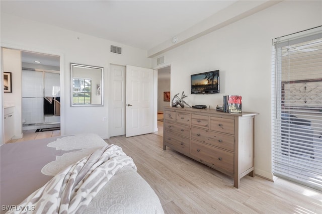 bedroom with light wood-type flooring, access to outside, and ensuite bath
