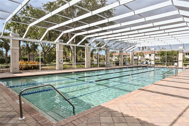 view of pool featuring glass enclosure and a patio