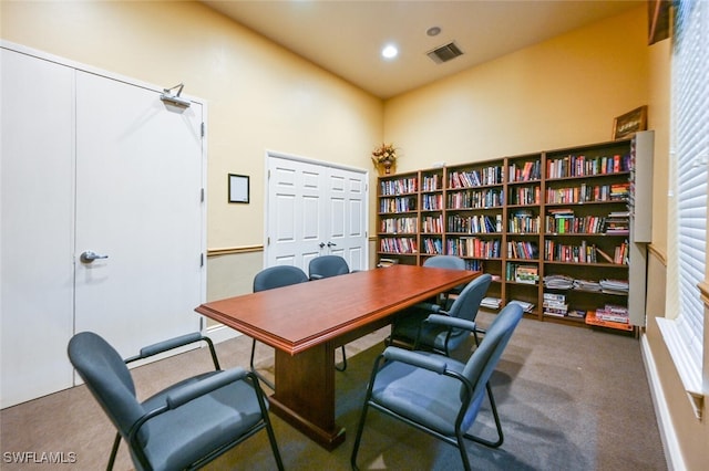 carpeted home office featuring a towering ceiling
