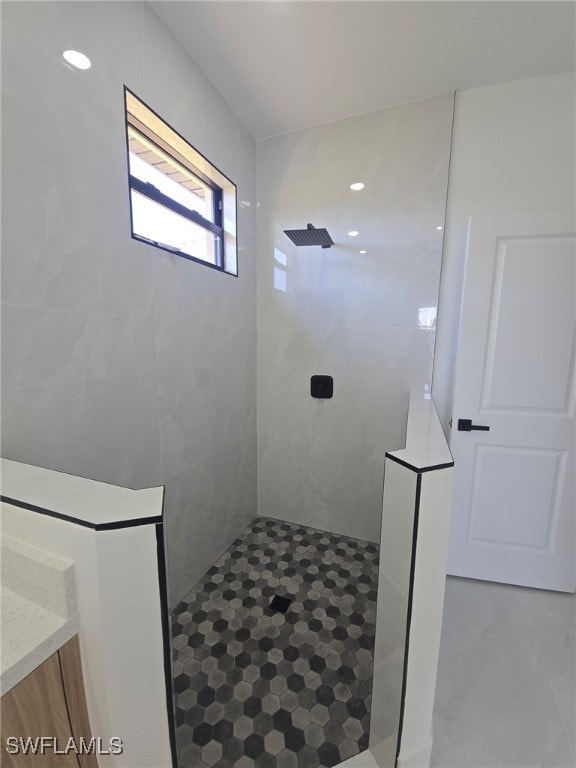 bathroom with vanity and a tile shower