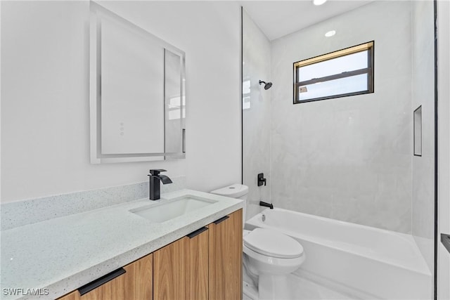 full bathroom with vanity, tiled shower / bath combo, and toilet