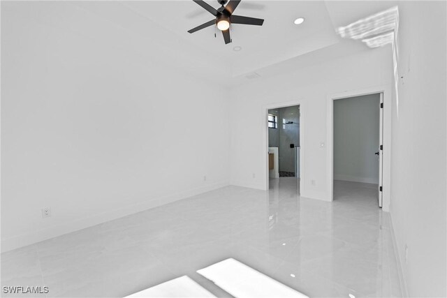 unfurnished room with a raised ceiling and ceiling fan