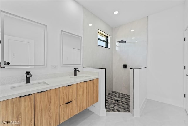 bathroom featuring tiled shower and vanity