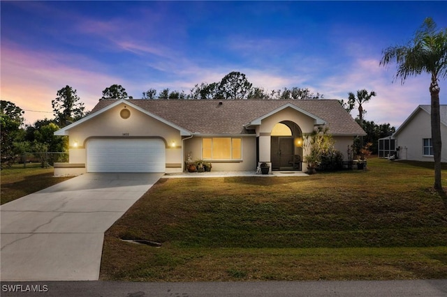 ranch-style house featuring a yard and a garage