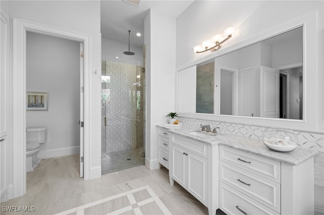 bathroom with a shower with door, vanity, and backsplash