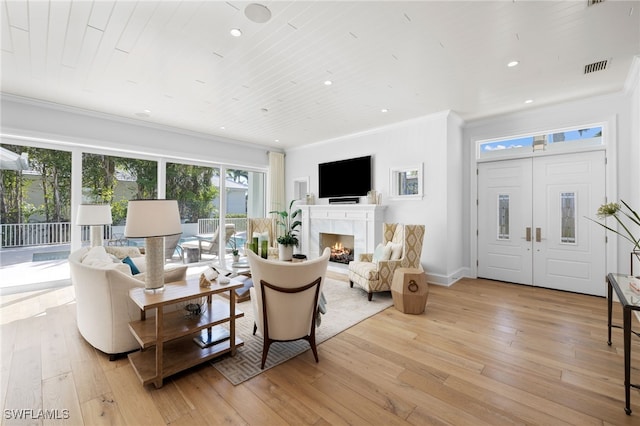 living room featuring ornamental molding, wood ceiling, and light wood-type flooring