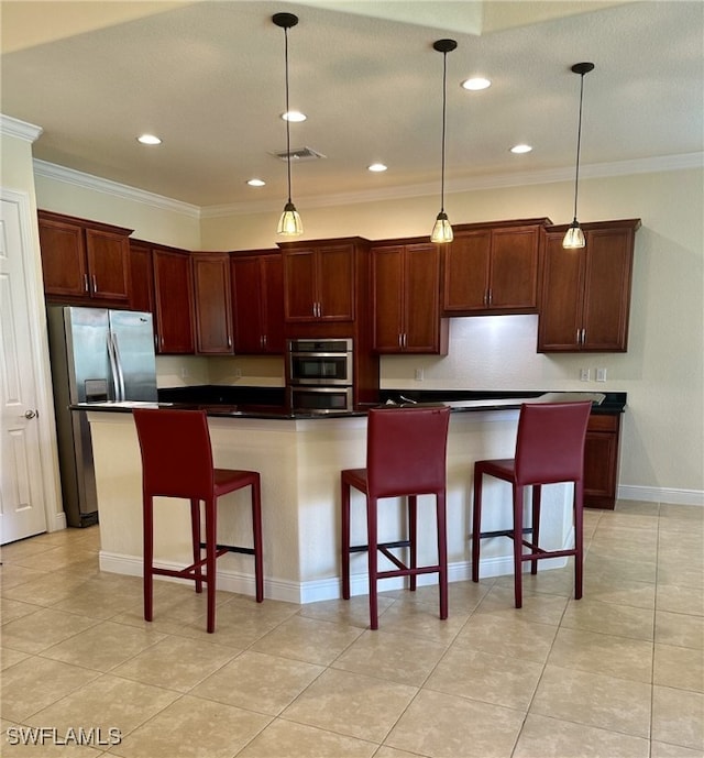 kitchen featuring pendant lighting, appliances with stainless steel finishes, a kitchen breakfast bar, and a kitchen island