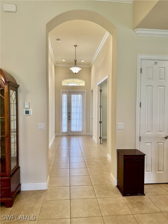 foyer featuring light tile patterned flooring, ornamental molding, and french doors