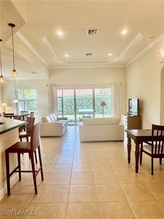 tiled living room with crown molding and a tray ceiling