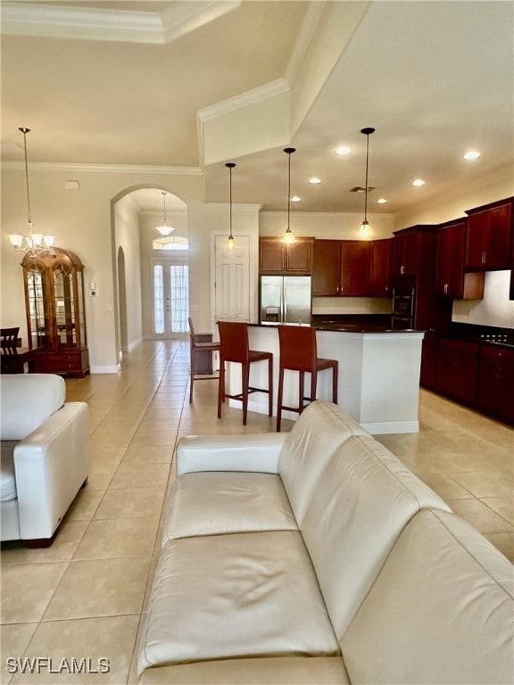 tiled living room with crown molding, a chandelier, and french doors