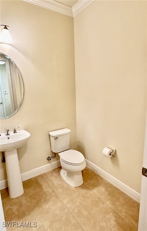 bathroom featuring sink, crown molding, tile patterned floors, and toilet