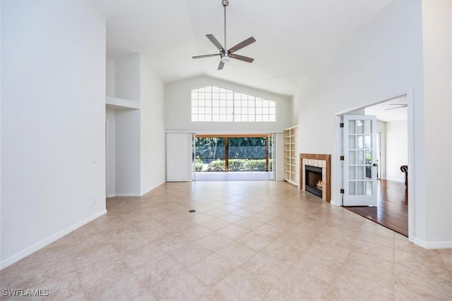 unfurnished living room featuring a tiled fireplace, ceiling fan, high vaulted ceiling, and light tile patterned floors