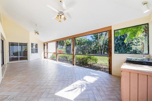 unfurnished sunroom featuring ceiling fan, lofted ceiling, and sink