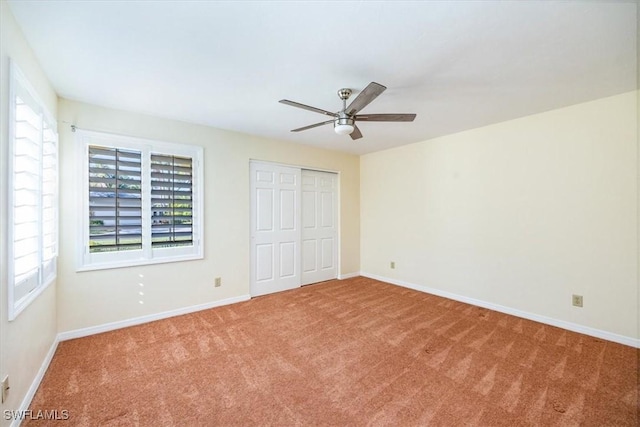 unfurnished bedroom with carpet flooring, multiple windows, a closet, and ceiling fan