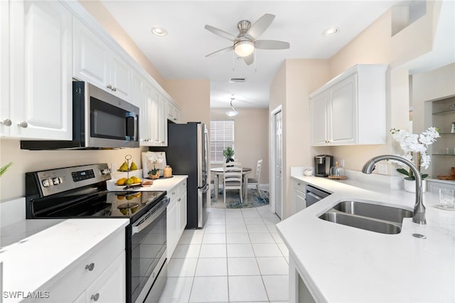 kitchen with white cabinets, sink, ceiling fan, light tile patterned floors, and appliances with stainless steel finishes