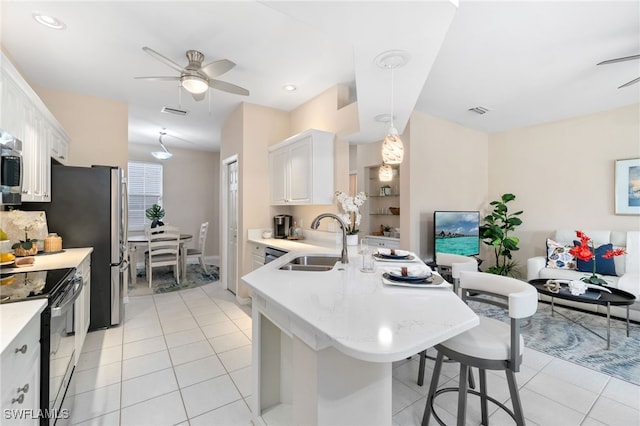 kitchen featuring white cabinets, a breakfast bar, black range with electric stovetop, and sink