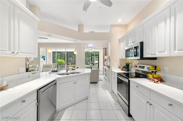 kitchen featuring white cabinetry, sink, light tile patterned flooring, and appliances with stainless steel finishes