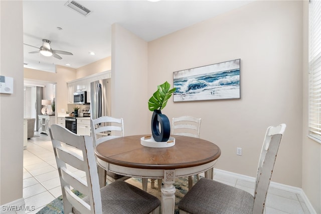 tiled dining space featuring ceiling fan