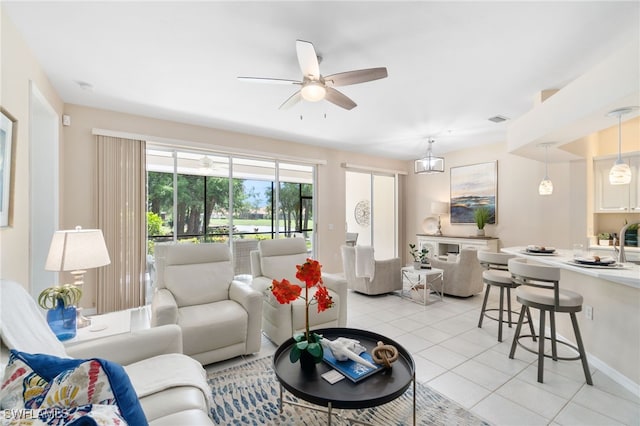 tiled living room featuring ceiling fan with notable chandelier