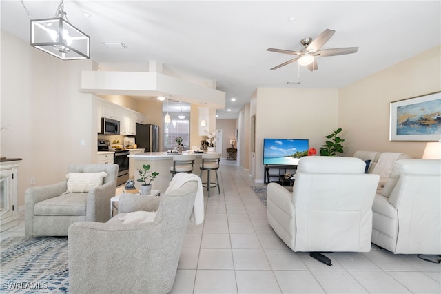 living room with light tile patterned floors and ceiling fan with notable chandelier