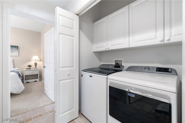 washroom with light carpet, cabinets, and independent washer and dryer