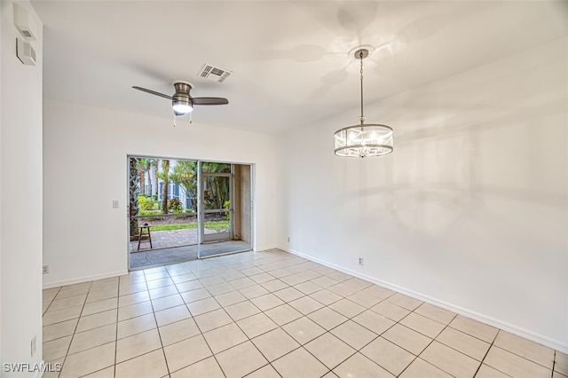 tiled spare room featuring ceiling fan with notable chandelier