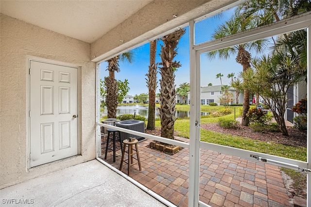 sunroom featuring a water view