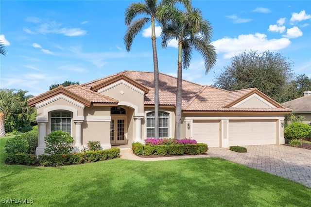 mediterranean / spanish-style home featuring a front yard and a garage