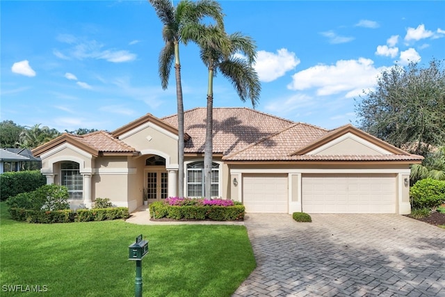 mediterranean / spanish home with a garage and a front yard