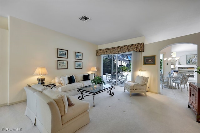 living room with light carpet and an inviting chandelier