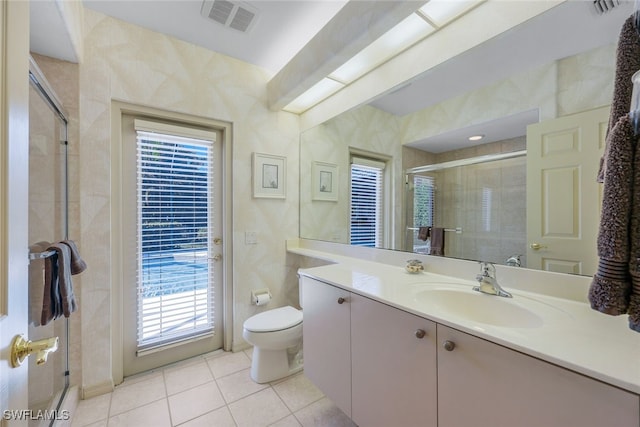 bathroom featuring tile patterned floors, vanity, toilet, and an enclosed shower