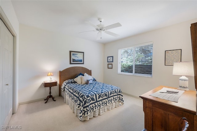 bedroom featuring ceiling fan, light colored carpet, and a closet