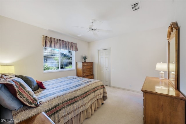 carpeted bedroom with ceiling fan and a closet