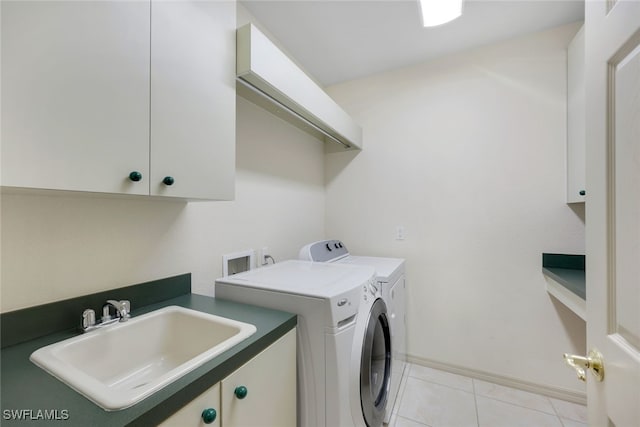 laundry room with cabinets, washing machine and dryer, light tile patterned floors, and sink