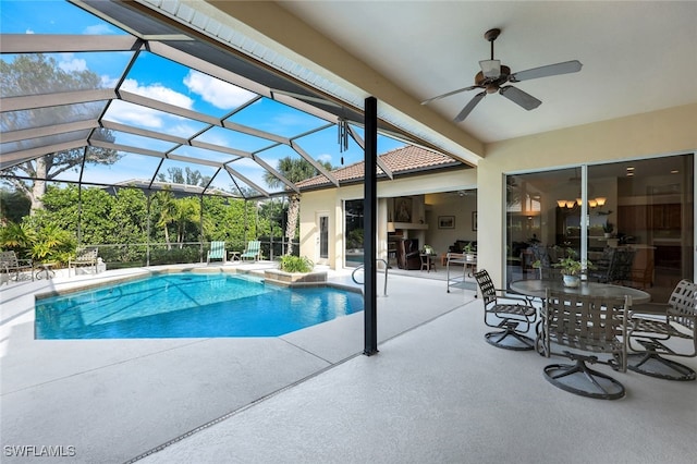 view of swimming pool featuring a patio, glass enclosure, and ceiling fan