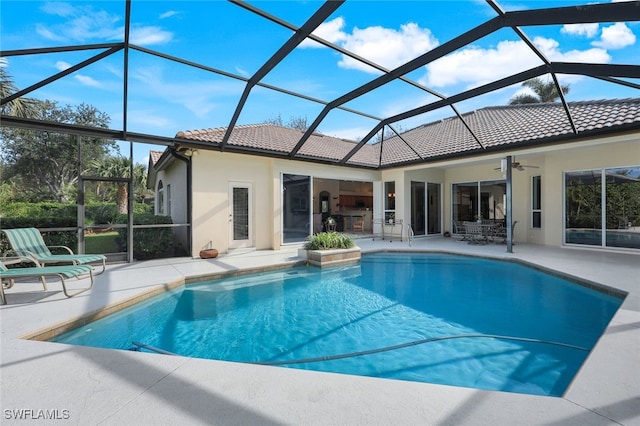 view of pool with ceiling fan, a patio area, and a lanai