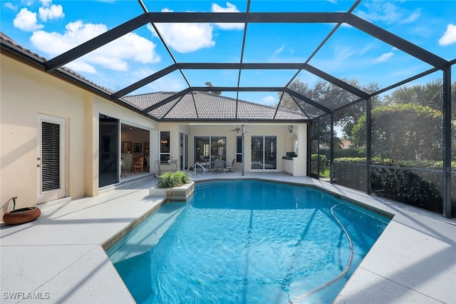 view of pool featuring a lanai, a patio area, and ceiling fan