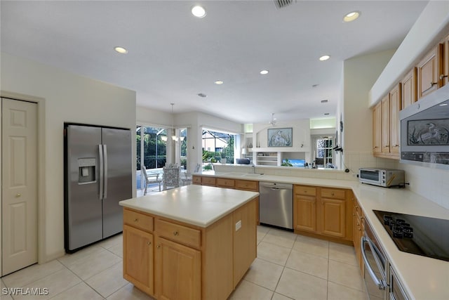 kitchen featuring sink, a kitchen island, light tile patterned floors, and appliances with stainless steel finishes