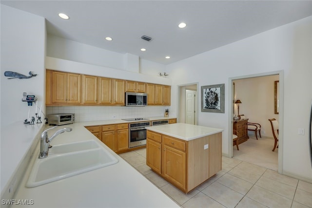 kitchen featuring light tile patterned flooring, sink, tasteful backsplash, a kitchen island, and stainless steel appliances