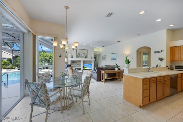 tiled dining area featuring sink and ceiling fan with notable chandelier