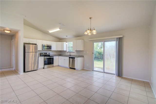 kitchen featuring white cabinetry, stainless steel appliances, hanging light fixtures, vaulted ceiling, and light tile patterned floors