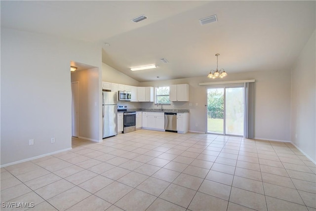 kitchen with light tile patterned flooring, white cabinetry, lofted ceiling, and appliances with stainless steel finishes