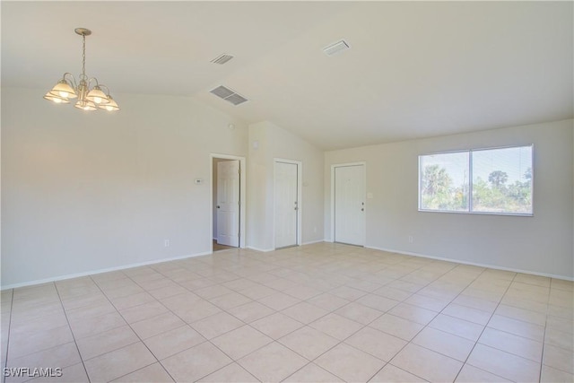 tiled spare room with a chandelier and vaulted ceiling