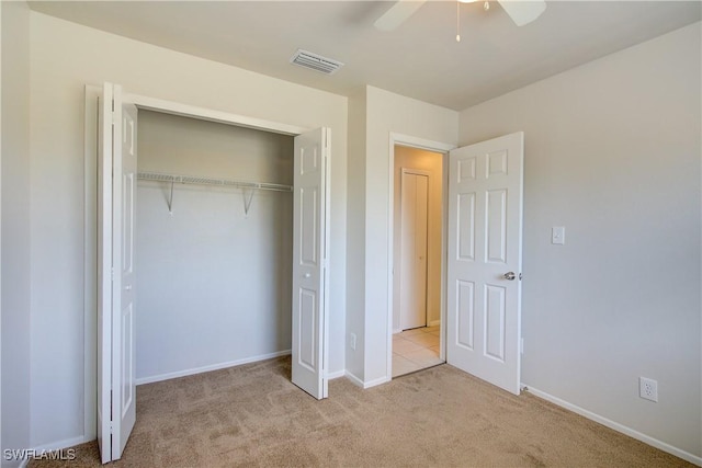 unfurnished bedroom with a closet, ceiling fan, and light colored carpet