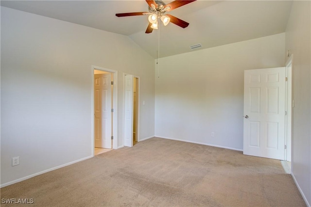 spare room featuring light colored carpet, vaulted ceiling, and ceiling fan