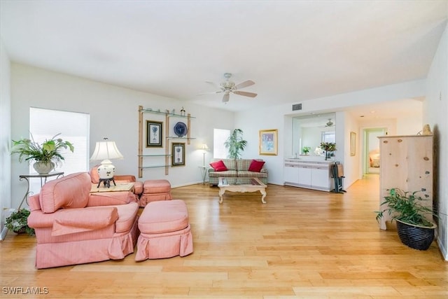 living room with ceiling fan and light hardwood / wood-style flooring