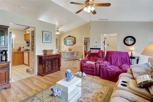 living room with light hardwood / wood-style floors, ceiling fan, and vaulted ceiling