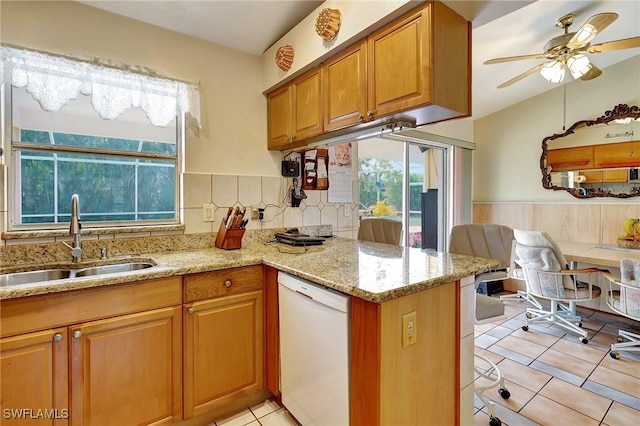 kitchen with ceiling fan, kitchen peninsula, sink, white dishwasher, and light tile patterned flooring